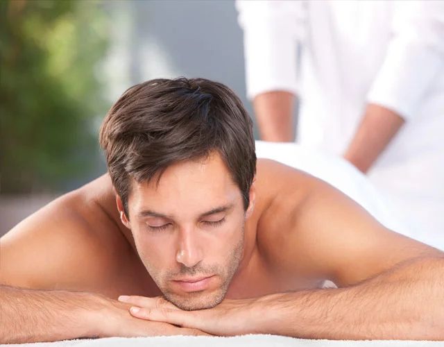 Hombre relajado con los ojos cerrados en masaje erótico