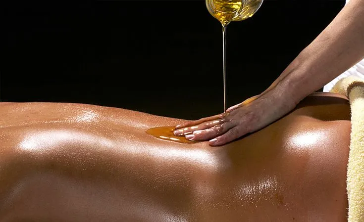 Derramando aceite en espalda antes de masaje