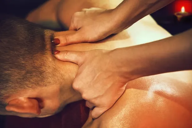 Masajista haciendo masaje en el cuello de un hombre