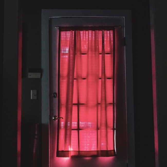 Ventana de una cuarto para masaje eróticos con una cortina roja