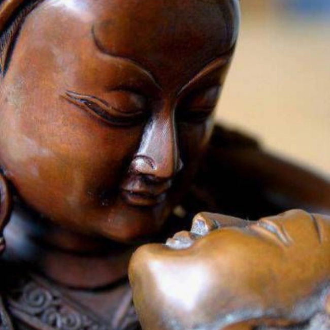 La imagen contiene dos estatuas de una cultura a punto de besarse.