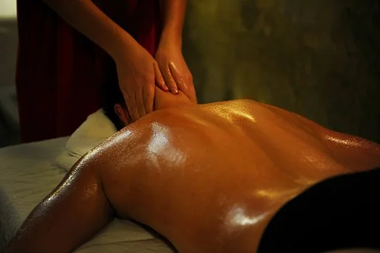 Cliente en manos de masajista recibiendo masaje