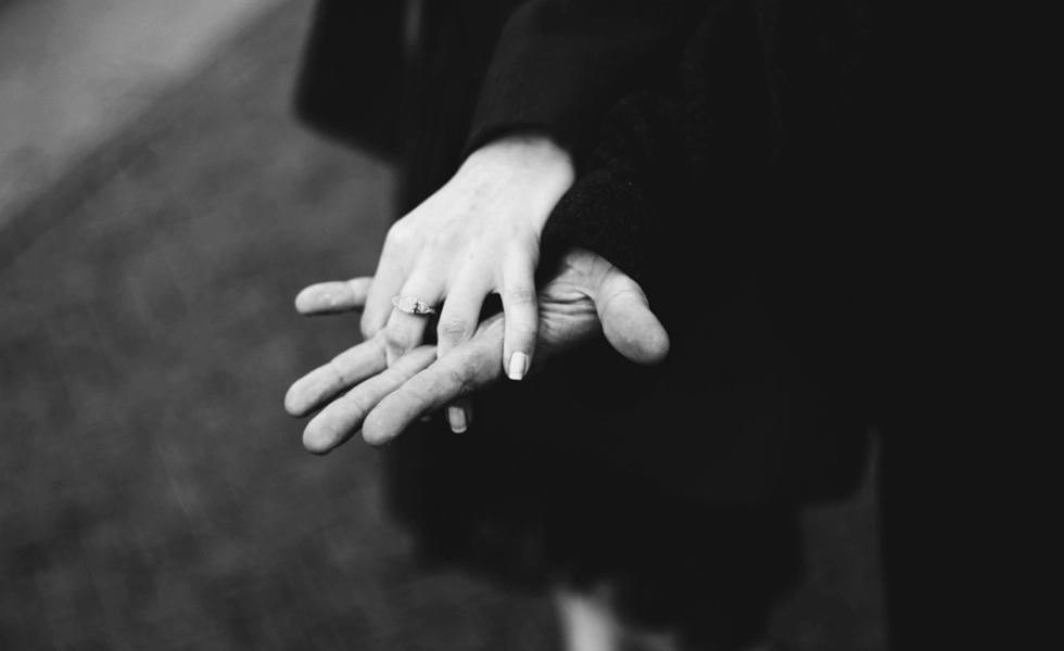 La mano de una mujer con un anillo agarran la mano de un hombre