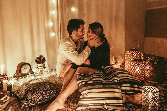 La imagen muestra a una pareja que se va a dar un masaje erótico en su propia casa
