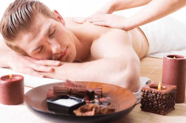 Hombre rubio acostado disfrutando de una masaje receptor